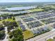 Community aerial shot of many gray roofed homes, ponds, and green fields near a highway under a partly cloudy sky at 1106 Tropea Ln, Auburndale, FL 33823