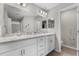 Bathroom with double vanity, marble countertop, framed mirrors, and a walk-in shower at 1106 Tropea Ln, Auburndale, FL 33823