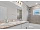 Bathroom showcases a double vanity with modern faucets, tiled shower, and large mirror at 1106 Tropea Ln, Auburndale, FL 33823