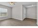 Bright bedroom with a window offering natural light and wood-look flooring, and a ceiling fan at 1106 Tropea Ln, Auburndale, FL 33823