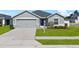 Charming single-story home with a well-manicured lawn and a two-car garage in a suburban neighborhood at 1106 Tropea Ln, Auburndale, FL 33823