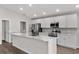 Bright kitchen features white cabinets, stainless steel appliances, a large island, and modern finishes at 1106 Tropea Ln, Auburndale, FL 33823