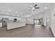 Open-concept living room with modern ceiling fan, stainless steel kitchen appliances, and sliding door access to the yard at 1106 Tropea Ln, Auburndale, FL 33823