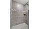 Updated walk-in shower features grey tile and a shower niche at 1106 Tropea Ln, Auburndale, FL 33823