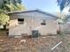 Back exterior of a single-story home with windows and siding, plus an HVAC unit and leaves at 1160 Austin St, Bartow, FL 33830