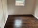 An empty room showcasing wood flooring and a single window providing natural light at 1160 Austin St, Bartow, FL 33830