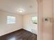 Bright bedroom with hardwood floors, two windows, and a thermostat on the wall at 1160 Austin St, Bartow, FL 33830