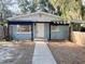 Charming single-story home featuring a black pergola and inviting front entrance in a tree-filled yard at 1160 Austin St, Bartow, FL 33830
