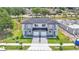 Aerial view showcases a modern duplex with lush landscaping, a lake, and a shared driveway at 1171 Windjammer Dr, Lakeland, FL 33803