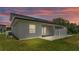Exterior back view of home showcasing a concrete pad and grass at 1171 Windjammer Dr, Lakeland, FL 33803