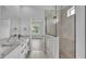 Bright bathroom featuring marble countertops, double sinks, and tiled walk-in shower at 1171 Windjammer Dr, Lakeland, FL 33803