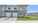 A modern duplex with two-car garages, well-manicured lawns, and a shared driveway at 1171 Windjammer Dr, Lakeland, FL 33803