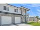 Beautiful modern exterior with a two-car garage, manicured lawn, and a balcony with white railings at 1171 Windjammer Dr, Lakeland, FL 33803