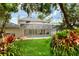 View of the backyard with the in-ground pool, patio, and home visible, as well as lush landscaping at 1218 Lake Point Ter, Lakeland, FL 33813