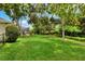 Expansive backyard lawn space, with screened in pool and patio visible in the distance at 1218 Lake Point Ter, Lakeland, FL 33813