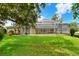Beautiful backyard with a large lawn area and a view of the screened-in pool at 1218 Lake Point Ter, Lakeland, FL 33813