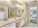 Bathroom with dual sinks, vanity, walk-in shower, and natural light at 1218 Lake Point Ter, Lakeland, FL 33813