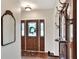 Traditional entryway featuring a wood door, coat rack, mirror, and hardwood floors at 1218 Lake Point Ter, Lakeland, FL 33813