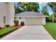 Attached two-car garage with driveway and mature landscaping adds to the home's curb appeal at 1218 Lake Point Ter, Lakeland, FL 33813