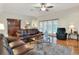 Comfortable living room with hardwood floors, leather sofas, and a bright view to the pool at 1218 Lake Point Ter, Lakeland, FL 33813