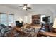 Bright living room with brick fireplace, leather sofas, and view of the pool through large windows at 1218 Lake Point Ter, Lakeland, FL 33813