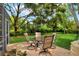 Outdoor patio seating on a brick patio, surrounded by green lawns and lush landscaping at 1218 Lake Point Ter, Lakeland, FL 33813