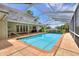 A sparkling screened-in pool featuring a brick patio and backyard access through French doors at 1218 Lake Point Ter, Lakeland, FL 33813