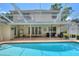 A lovely view of the pool area from the pool, with French doors and a second story balcony at 1218 Lake Point Ter, Lakeland, FL 33813