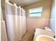 Retro bathroom with pink tile, a window for natural light, and standard fixtures at 135 E Columbia St, Lake Alfred, FL 33850