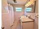 Retro bathroom with pink tile, a window for natural light, and standard fixtures at 135 E Columbia St, Lake Alfred, FL 33850