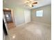 This bedroom has neutral walls, terrazzo floors, and a ceiling fan with light at 135 E Columbia St, Lake Alfred, FL 33850