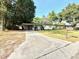 Home exterior with long driveway and lawn at 135 E Columbia St, Lake Alfred, FL 33850