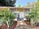 Inviting screened front porch featuring a seating area, creating a welcoming entrance at 135 E Columbia St, Lake Alfred, FL 33850