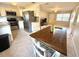 Open kitchen and dining area featuring stainless steel appliances, terrazzo floors, and ample cabinet space at 135 E Columbia St, Lake Alfred, FL 33850