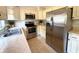 Traditional kitchen featuring white cabinetry, stainless steel appliances, and speckled flooring, offering a functional space at 135 E Columbia St, Lake Alfred, FL 33850