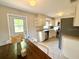 Traditional kitchen featuring white cabinetry, stainless steel appliances, and speckled flooring, offering a functional space at 135 E Columbia St, Lake Alfred, FL 33850