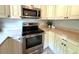 This traditional kitchen has white cabinetry, stainless steel appliances, and speckled flooring at 135 E Columbia St, Lake Alfred, FL 33850