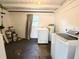 Laundry room with white appliances, white walls, dark floor and one window at 135 E Columbia St, Lake Alfred, FL 33850