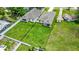 An aerial view showcases two white homes with fenced yards and green grass at 1415 S Lincoln Ave, Lakeland, FL 33803
