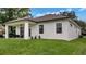 Back view of home with a covered porch and a large green lawn at 1415 S Lincoln Ave, Lakeland, FL 33803