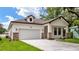 This exterior showcases a home with a garage and manicured landscaping, enhancing its curb appeal at 1415 S Lincoln Ave, Lakeland, FL 33803