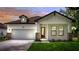 Inviting exterior view of a charming single-Gathering home featuring a manicured lawn and attached two-car garage at 1415 S Lincoln Ave, Lakeland, FL 33803
