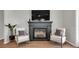 A sleek fireplace is flanked by two chairs in a living space with hardwood floors and light walls at 1415 S Lincoln Ave, Lakeland, FL 33803