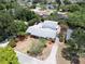 Aerial view showcases a home with a pool, mature trees, and a long driveway leading to the residence at 16 Golfview Ne Cir, Winter Haven, FL 33881