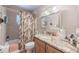 Bathroom vanity with wood cabinetry and granite countertop, complemented by a tiled shower at 16 Golfview Ne Cir, Winter Haven, FL 33881