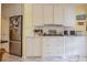 Well-lit kitchen with stainless steel refrigerator and modern appliances, complemented by white cabinets at 16 Golfview Ne Cir, Winter Haven, FL 33881