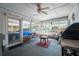 Enclosed patio area featuring a ceiling fan, outdoor seating, and access to the backyard at 16 Golfview Ne Cir, Winter Haven, FL 33881