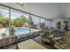 Enclosed patio area with comfortable seating and a view of the sparkling pool and backyard at 16 Golfview Ne Cir, Winter Haven, FL 33881