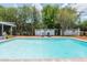 View of the sparkling in-ground pool surrounded by lush landscaping and a privacy fence at 16 Golfview Ne Cir, Winter Haven, FL 33881