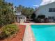 View of the pool and the shed in a yard featuring an in-ground pool, landscaping, and a white shed at 16 Golfview Ne Cir, Winter Haven, FL 33881